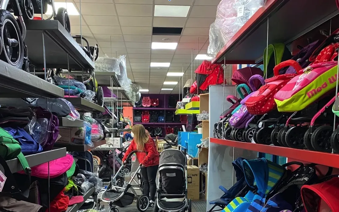 Inside a baby travel shop, with pushchairs and car seats on the shelves