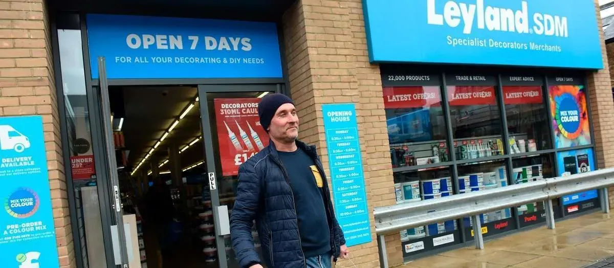 Man walking out of a Leyland SDM decorators' merchant